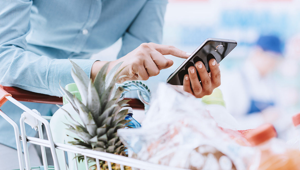 A person using their phone while grocery shopping