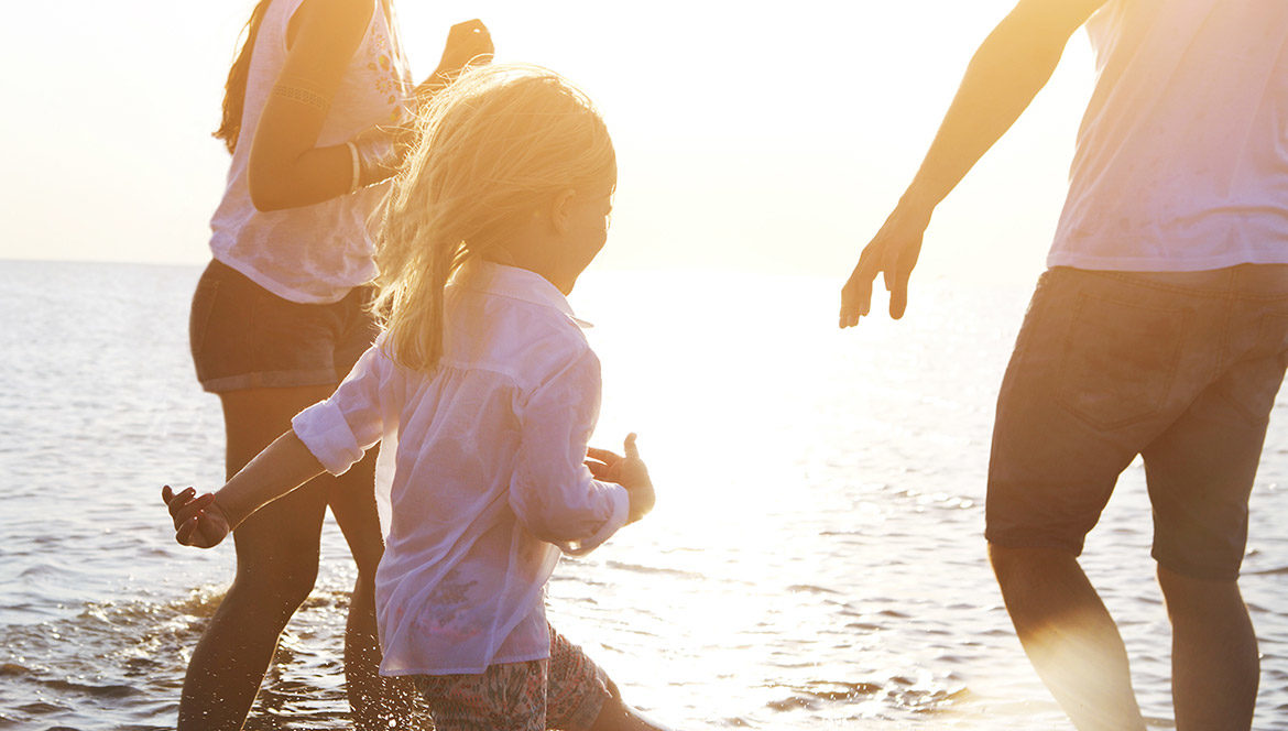 Parents and a child splashing in the waves