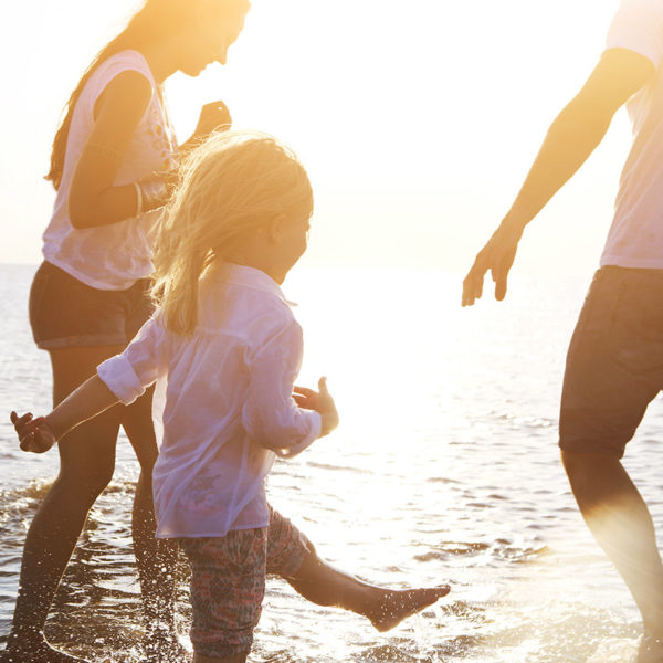 Parents and a child splashing in the waves