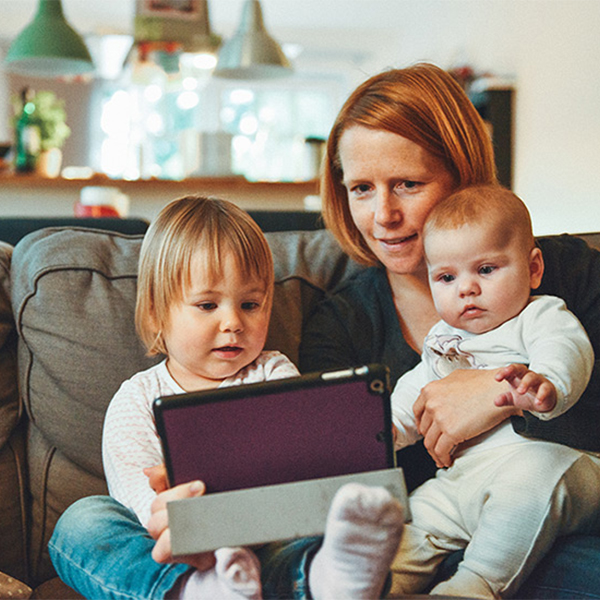 A mother and two children looking at a tablet