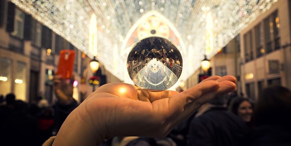 A hand holding a crystal ball to the light