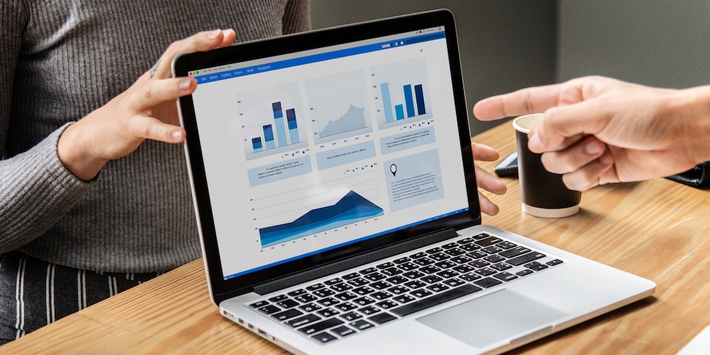 A hand pointing to data visualization on a laptop screen