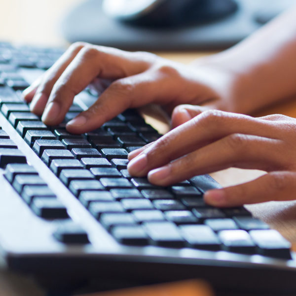 Hands poised over a computer keyboard