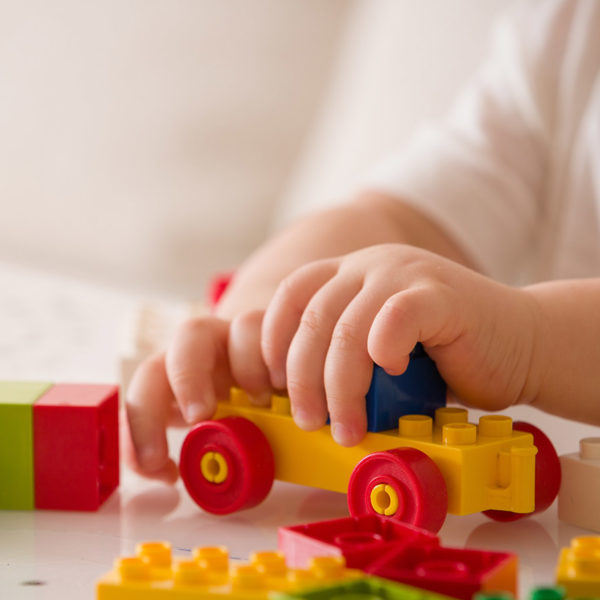 A close up of a child's hands, playing with building blocks