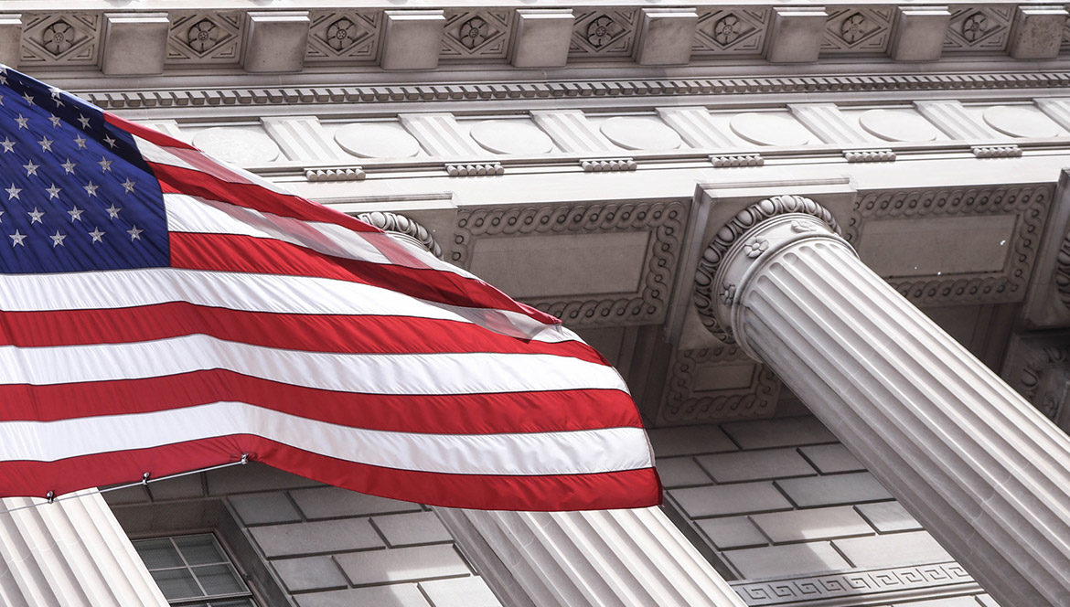 Columns of a courthouse with the US flag