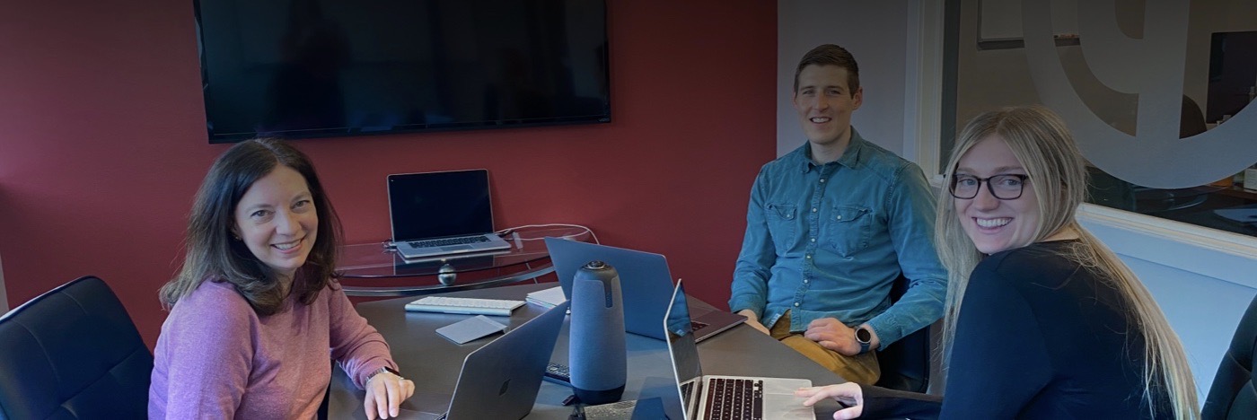 Three members of the PWW team seated in a conference room.