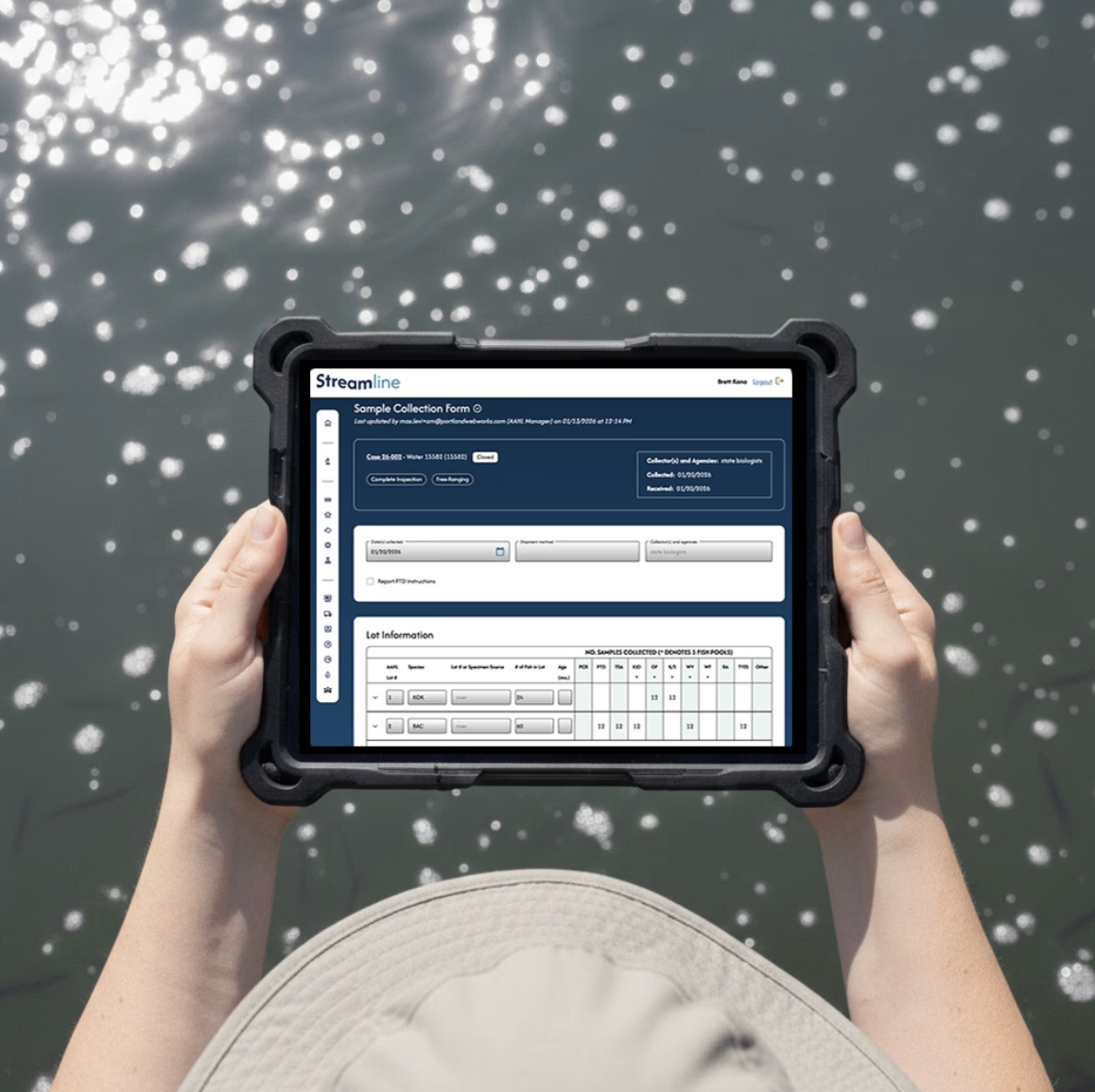A person in a hat holding a tablet over water showing the Streamline app