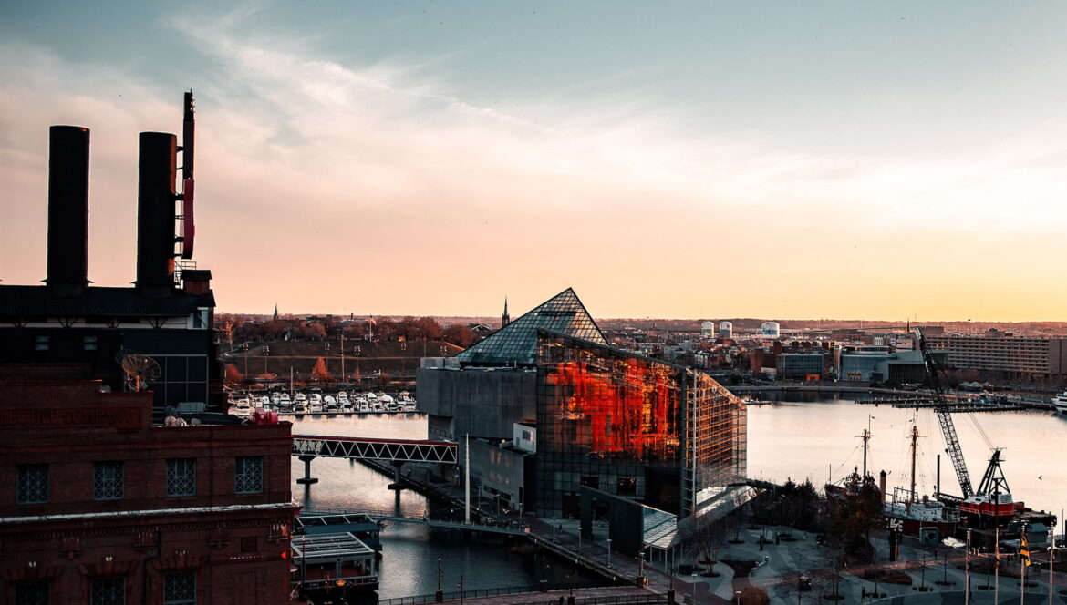 Sunrise over the water near city buildings in Maryland