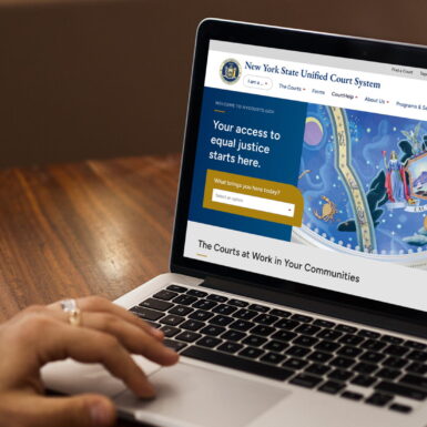 New York State Unified Court System (UCS) website on a laptop