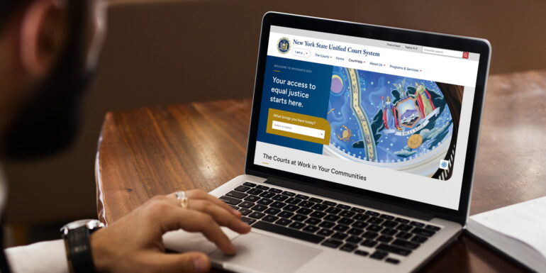 New York State Unified Court System (UCS) website on a laptop