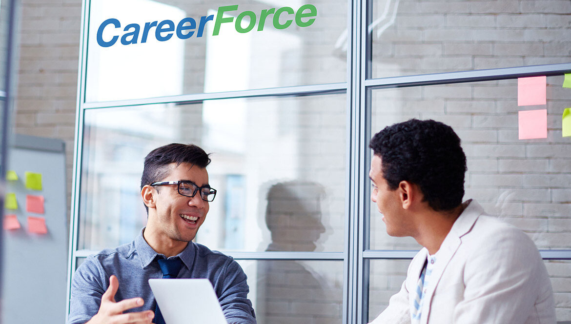 Two people talking next to a laptop with a CareerForce logo above